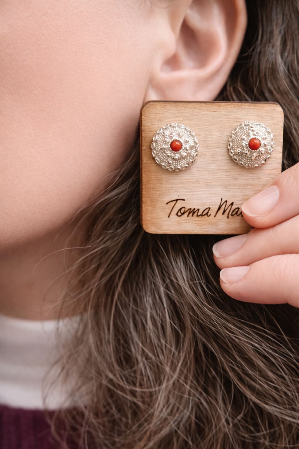 Orecchini bottone sardo in argento 925 con corallo naturale lavorati in filigrana sarda presentati su modella con supporto TomaMate Style